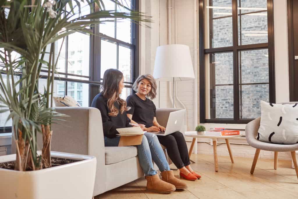 Two Shopify employees sitting on a sofa